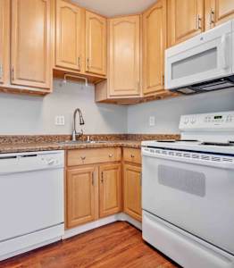 a kitchen with white appliances and wooden cabinets