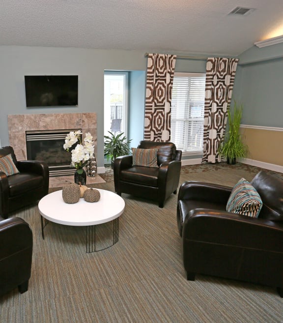 a living room with leather furniture and a fireplace