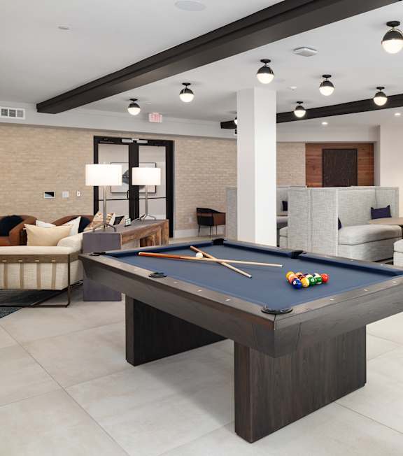 a clubhouse with a pool table in the middle of it