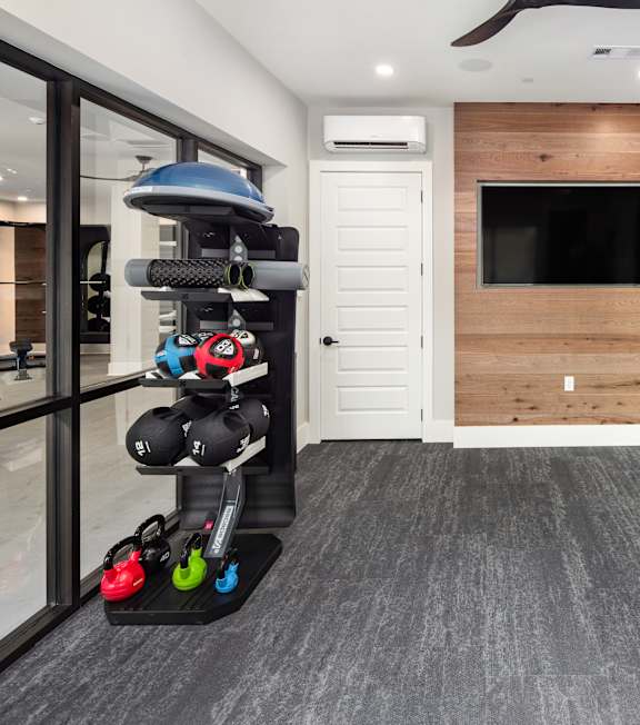 a home gym with weights and a tv on the wall