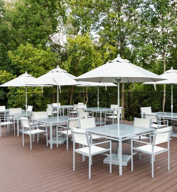a patio with tables and chairs and umbrellas