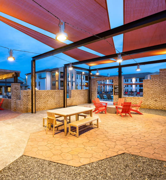 a patio with tables and chairs and a building in the background