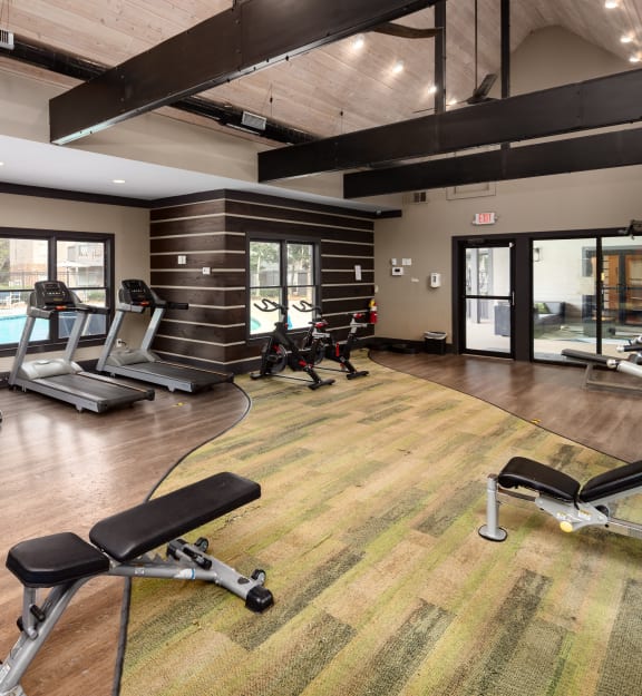 a gym with treadmills and other exercise equipment and a pool
