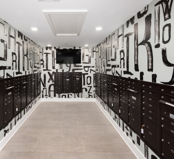 a hallway with lockers and a television in a room with graffiti on the wall