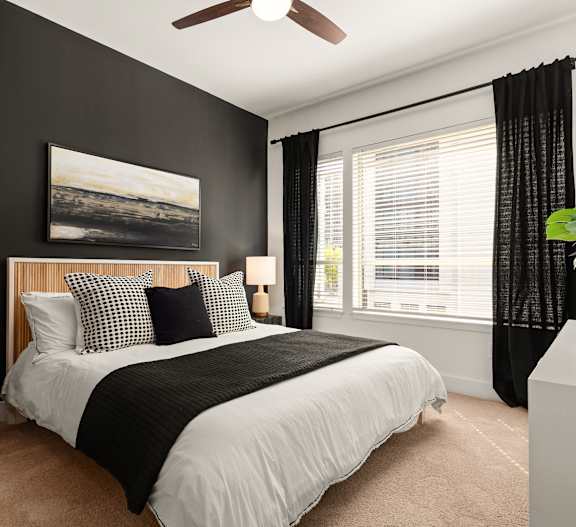 a bedroom with a bed and a ceiling fan