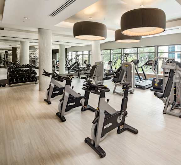 a gym with treadmills and other exercise equipment on a wooden floor