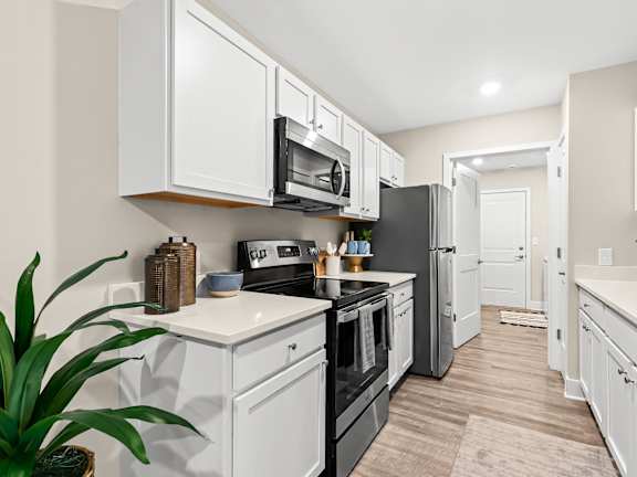a kitchen with white cabinets and black appliances and a black refrigerator