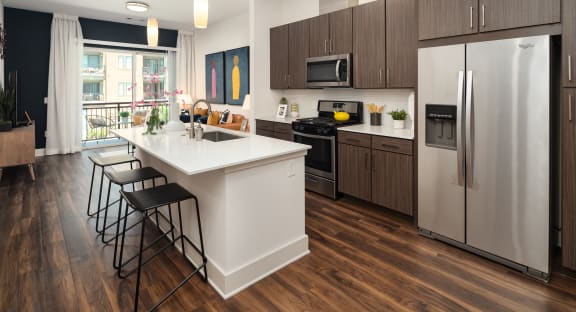 a kitchen with a large island and stainless steel appliances