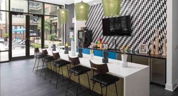 a long white counter in a room with chairs and a television