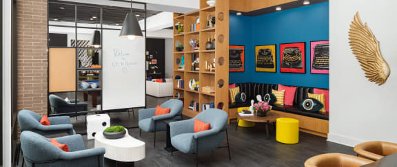 a lounge area with chairs and tables and a whiteboard