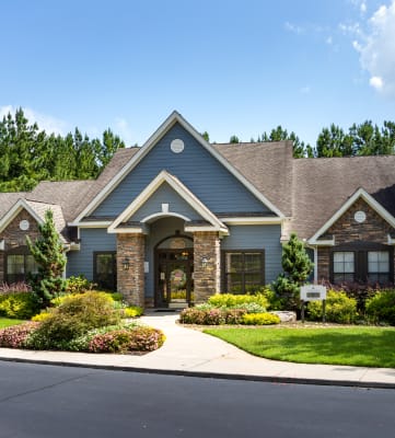 Exterior of the leasing office and resident clubhouse with lush landscaping at Heritage at Riverstone in Canton, GA