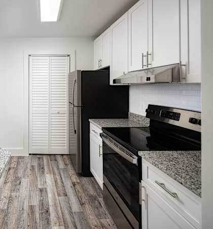A kitchen with a sink, stove, and refrigerator.