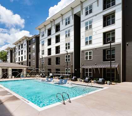 A swimming pool in front of apartment buildings.