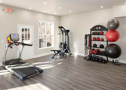 a home gym with exercise equipment and weights on a rack