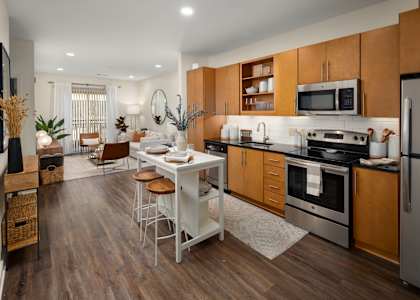 a kitchen and dining room with wooden cabinets and stainless steel appliances