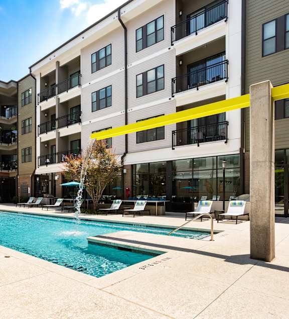 a swimming pool in front of an apartment building