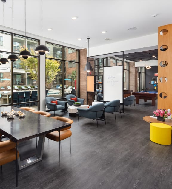 a communal area with a table and chairs and a large window