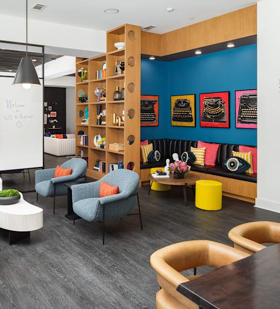 a lounge area with chairs and tables and a whiteboard