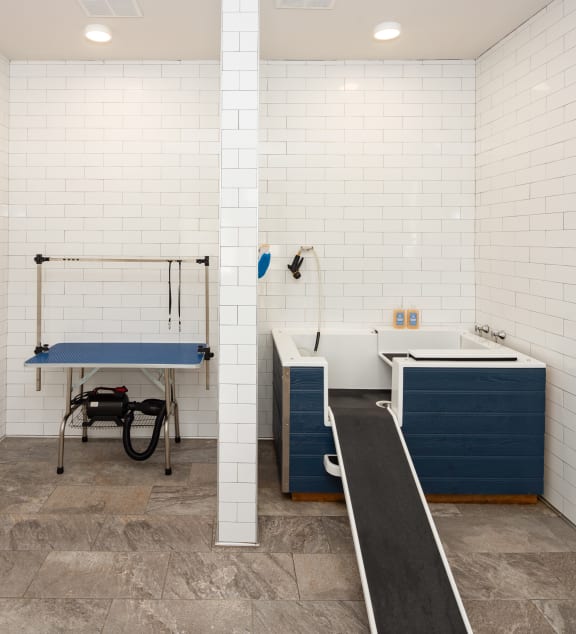 a locker room with a sink and a bath tub and aigmigmigmot