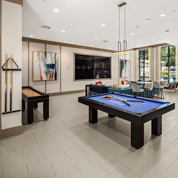 A billiard table is in the middle of a room with a pool table and a bar.