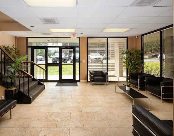 A black and white staircase leads to a waiting area with black furniture.