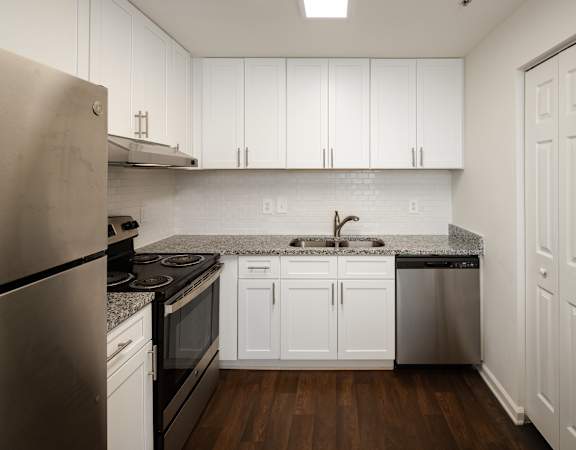 a kitchen with white cabinets and stainless steel appliances