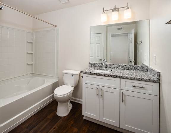 A white bathroom with a toilet, sink, and bathtub.