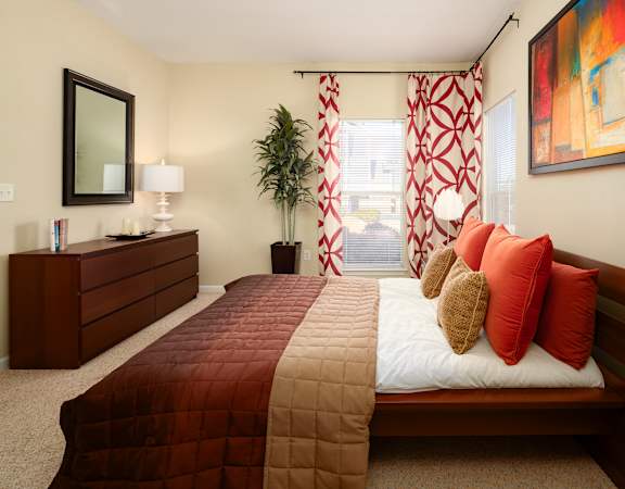 A bedroom with a large bed and a painting on the wall.