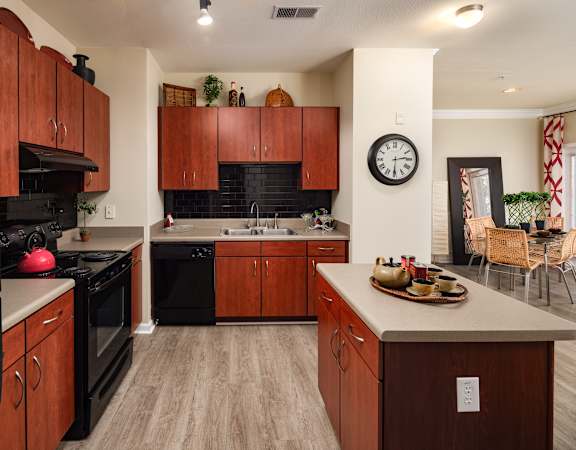 A kitchen with wooden cabinets and black appliances.