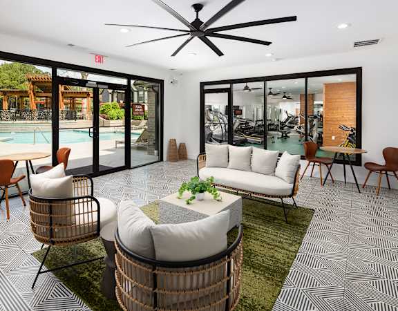 A modern living room with a pool outside the window.