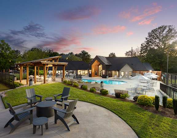 A backyard with a pool and a table set for six.