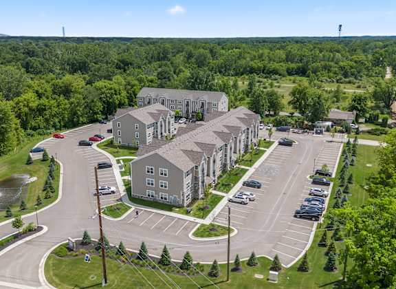 A large building complex with a parking lot in front.