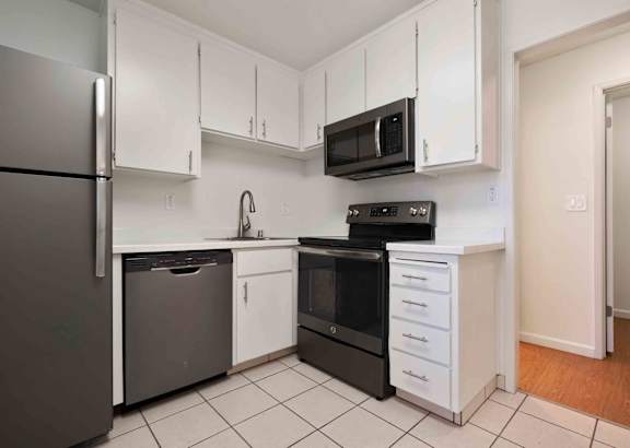 Two Bedroom Apartments in San Jose CA - Village of Taxco - Modern Ktichen with White Cabinetry, Tile Flooring, Stainless Steel Flooring, in a Separate Room, with View of Hallway