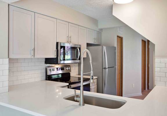 a kitchen with a sink and a refrigerator at Seasons Villas, Woodbury, 55125