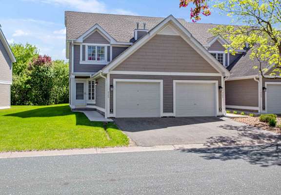 the front of a house with a driveway and a garage door at Seasons Villas, Woodbury Minnesota