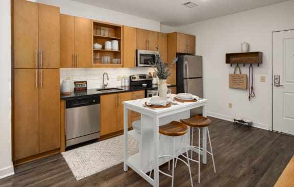 a kitchen with wooden cabinets and a white table with stools