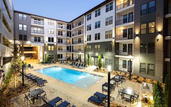 an apartment building with a swimming pool at night