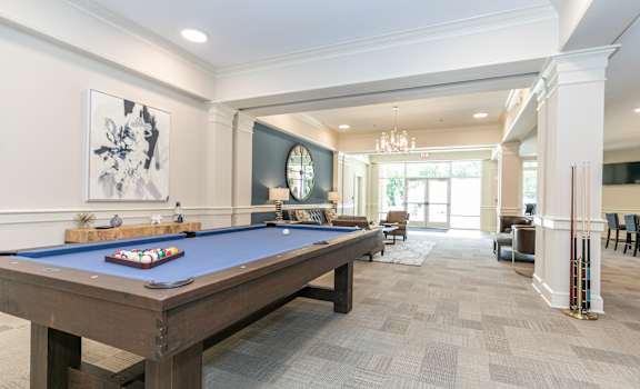 a billiards table in a clubhouse with a view of the living room at The Station at River Crossing, Macon, GA