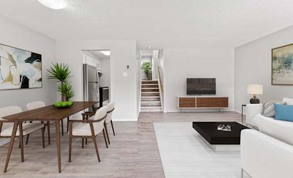 A modern living room with a wooden dining table and chairs.