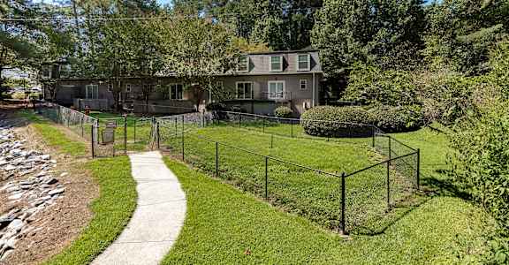 a house with a fenced in yard and a sidewalk