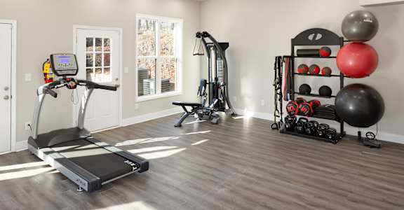a home gym with exercise equipment and weights on a rack