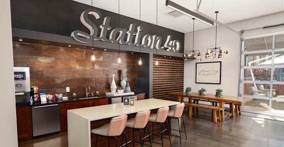 a dining room with a long table and chairs in front of a wall with a