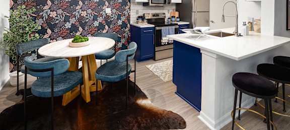 a kitchen with blue cabinets and a table and chairs