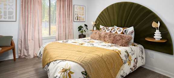 a bedroom with a bed with a green headboard