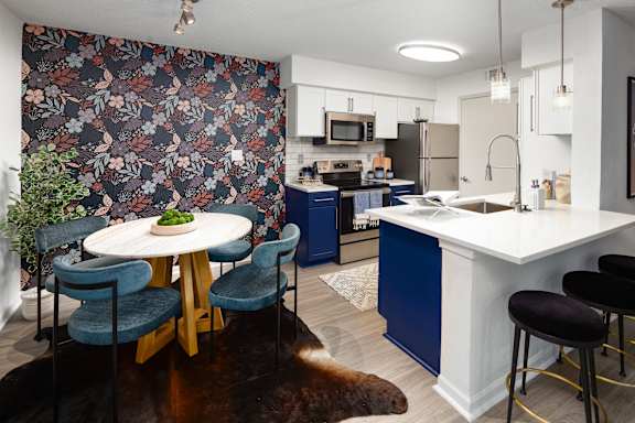 a kitchen with blue cabinets and a table and chairs