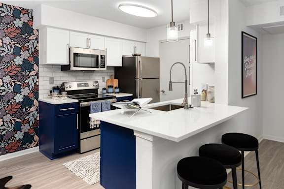a kitchen with a white counter top and a stainless steel refrigerator