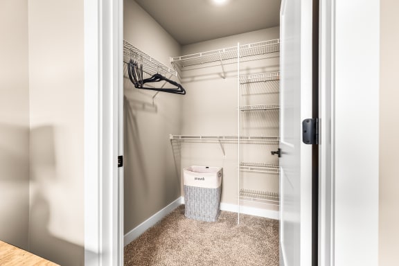 a walk in closet with a basket and wire shelving