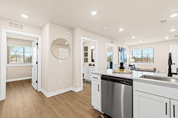 a renovated kitchen with white cabinets and a stainless steel dishwasher