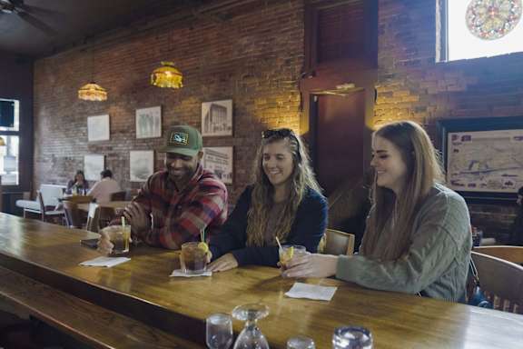 Four people sitting at a bar with drinks. at Riverfront Everett, Washington, 98201