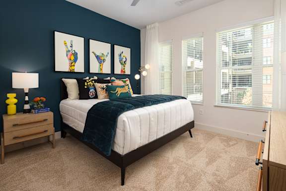 a bedroom with a bed and three windows
